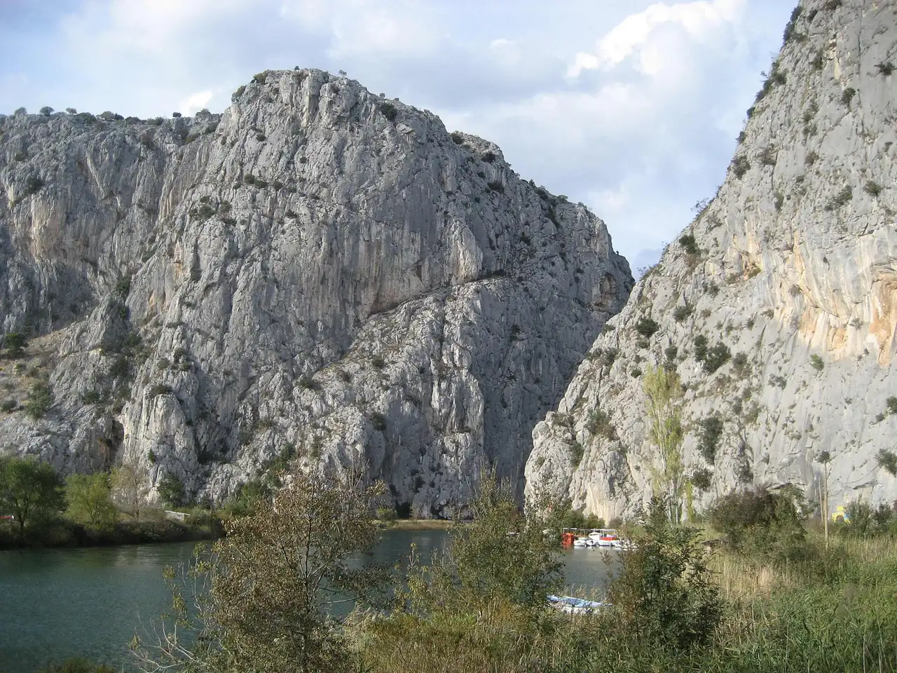 Canyoneers in wetsuits crossing a green pool in the Cetina canyon below Zadvarje