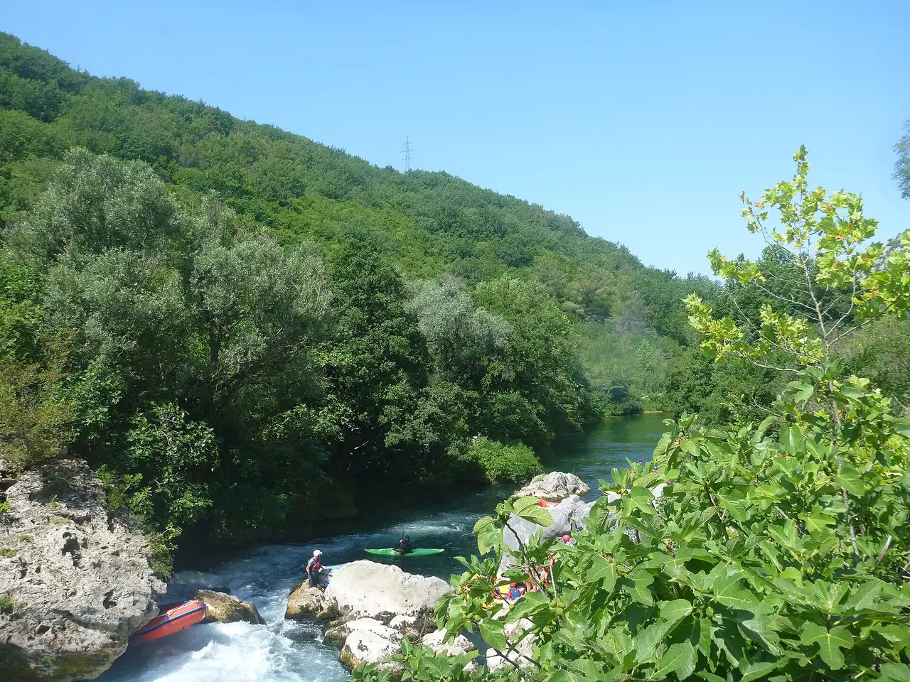 Kayaks on the emerald water of the Zrmanja between the white limestone walls of its canyon
