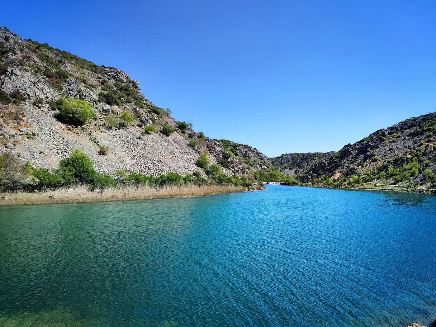 The Krupa river breaking into nine tufa terraces above the green Zrmanja canyon