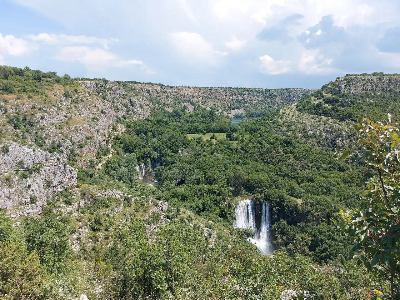 The multi-step travertine curtain of Manojlovac slap seen from the canyon viewpoint above the Krka river