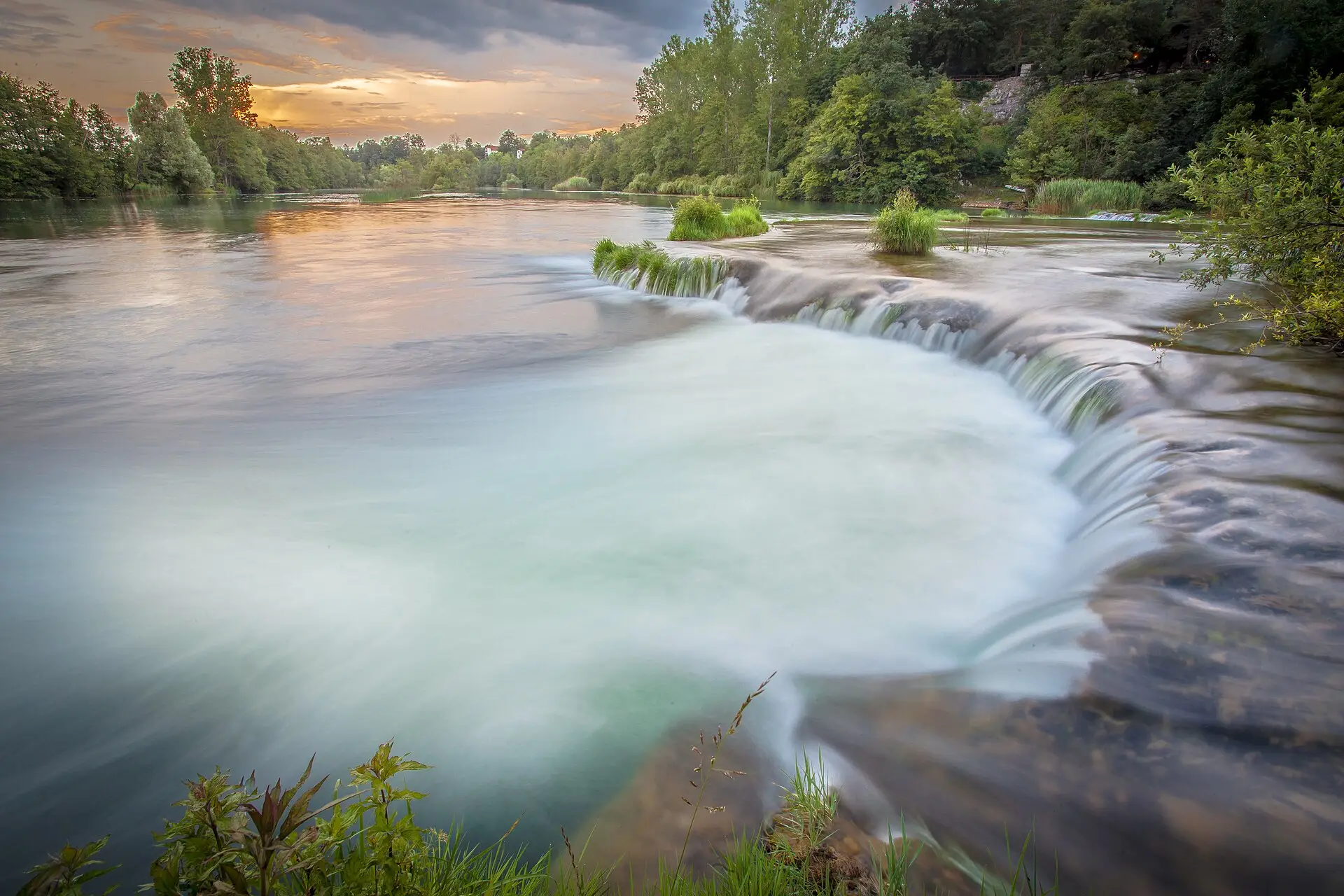 Stacked tufa basins of the Mrežnica waterfalls with warm green water in summer